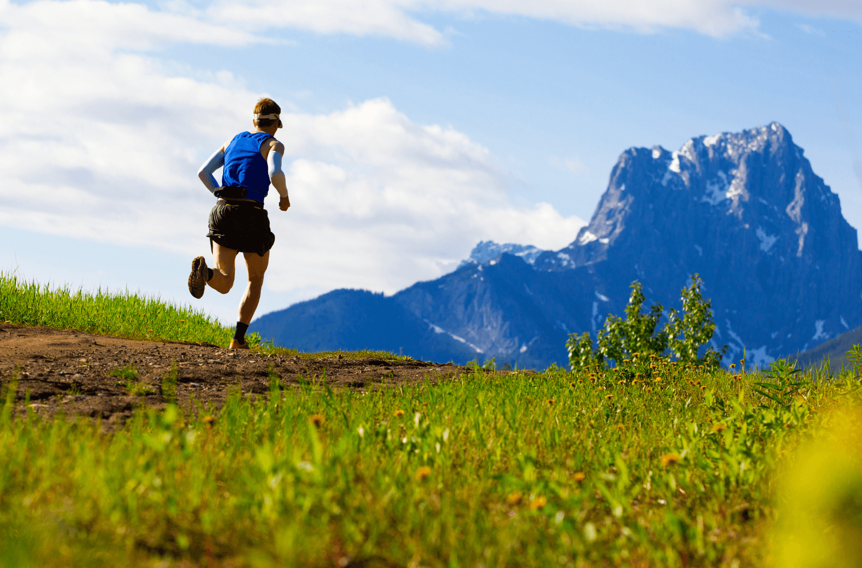 Man running with hydration pack in mountains